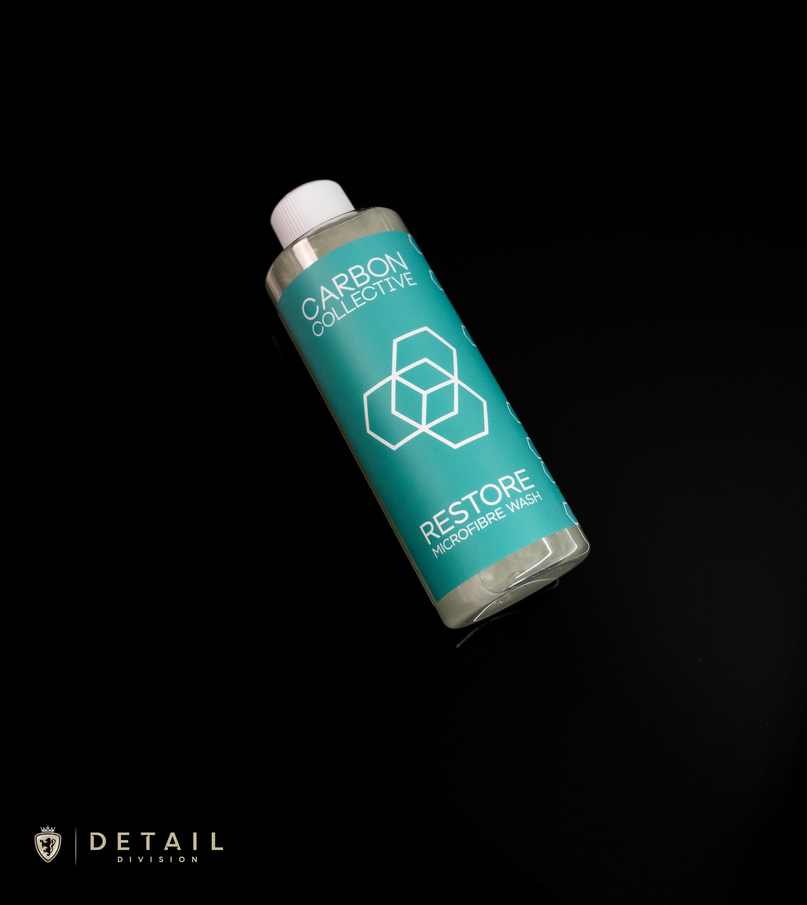 A bottle of Carbon Collective Restore Microfibre Wash on a dark background with the brand's logo visible on the label.